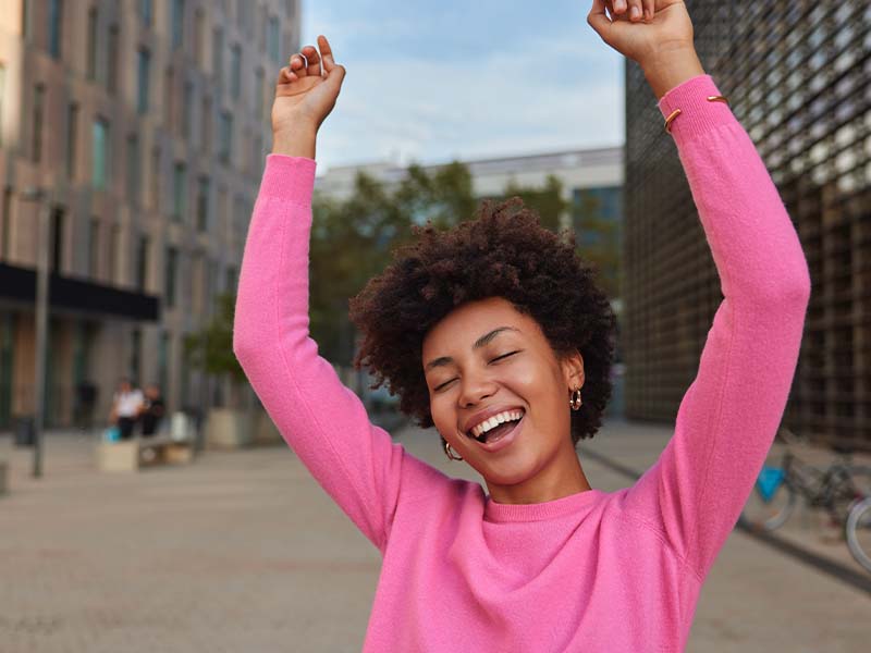Woman smiling in a pink sweater
